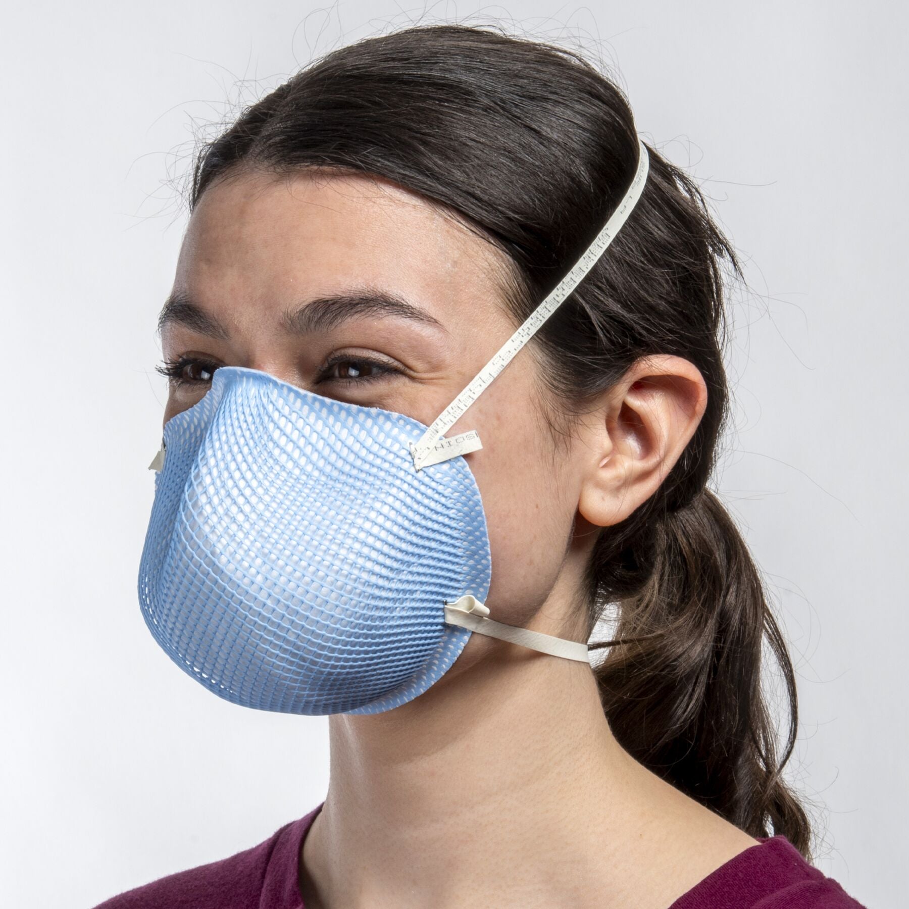 Woman healthcare worker wearing blue small healthcare NIOSH N95 surgical respirator from Canada Strong Masks.