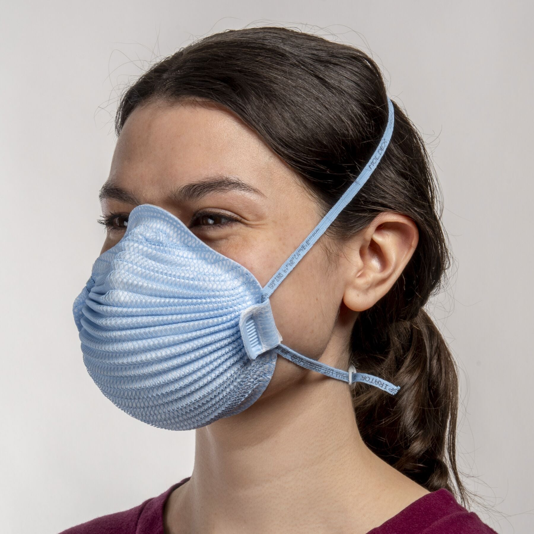 Woman healthcare worker wearing small blue Airwave 4651 NIOSH N95 surgical respirator from Canada Strong Masks.